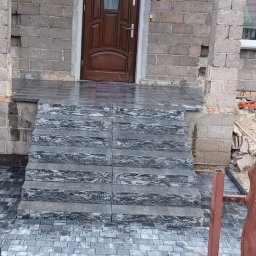 Fil-bruk - Ułożone schody z kostki granitowej prowadzące do wejścia domu w Częstochowie, widoczne ślady prac budowlanych w otoczeniu.