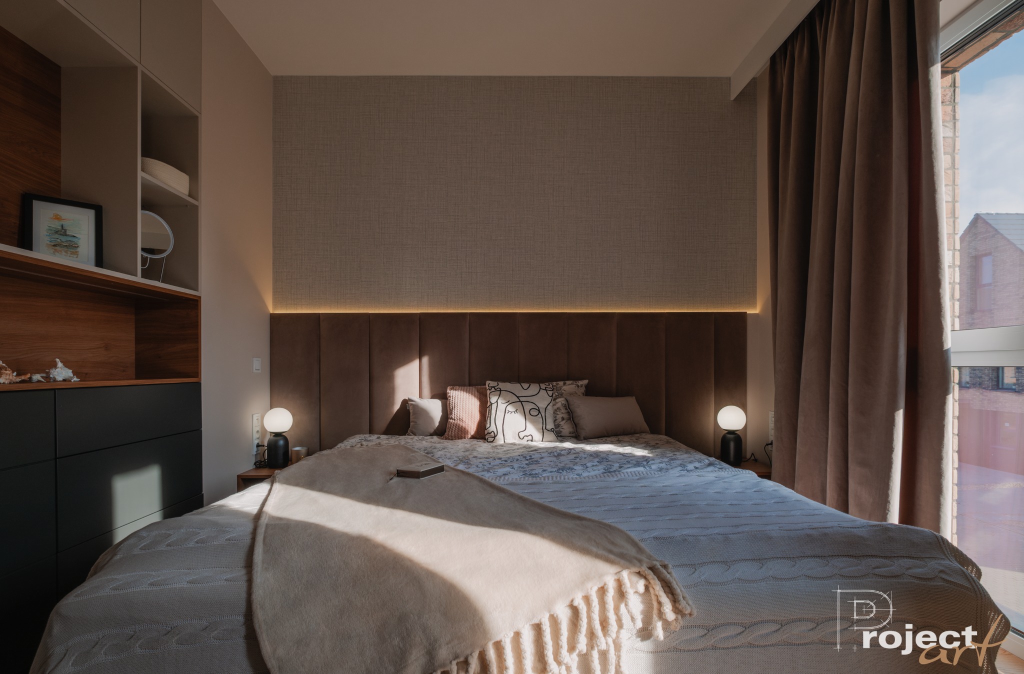 Elegancka sypialnia w Warszawie z podświetlanym wezgłowiem łóżka, beżowymi zasłonami i minimalistycznymi lampkami nocnymi, uzupełniona o zabudowę meblową z otwartymi półkami.