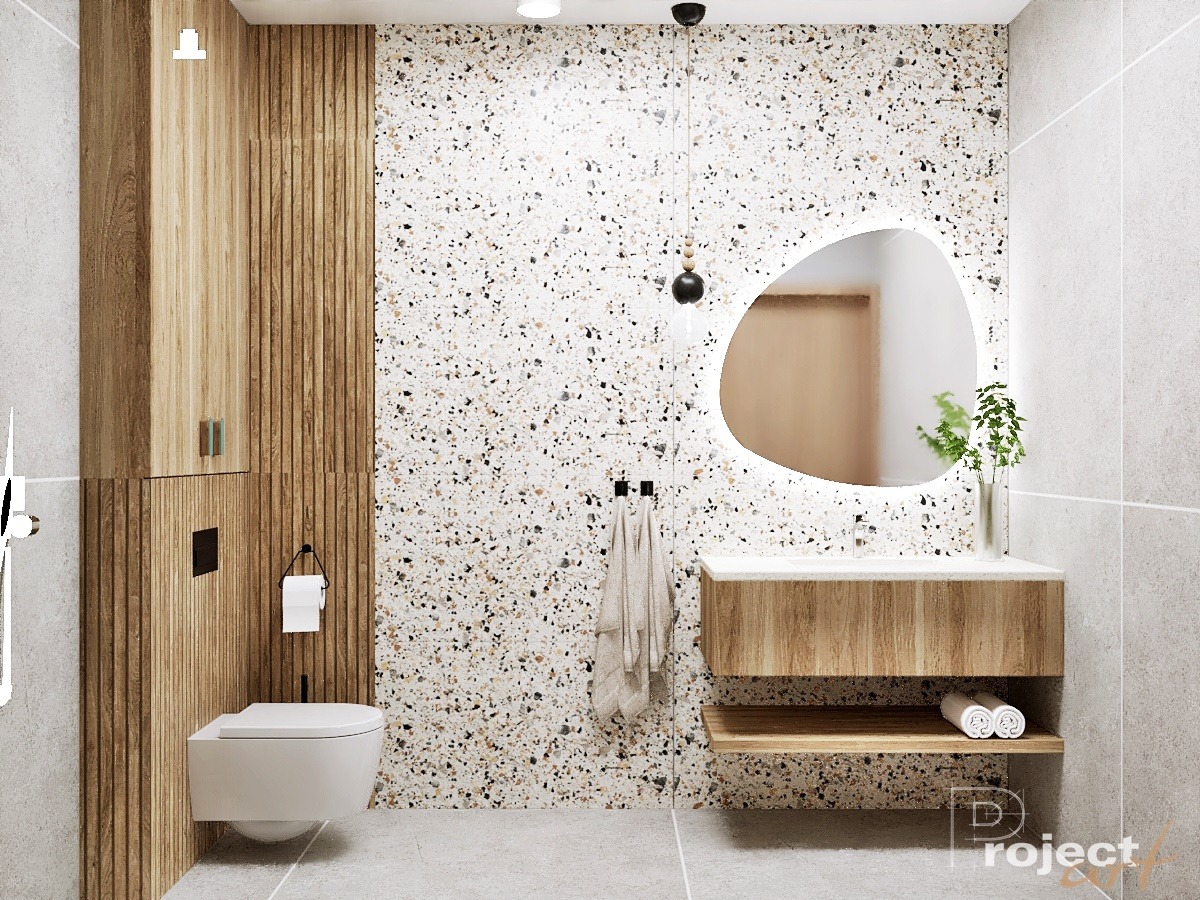 Nowoczesna łazienka z umywalką z drewnianą szafką, asymetrycznym lustrem z podświetleniem LED, ścianą w stylu lastryko i toaletą podwieszaną.