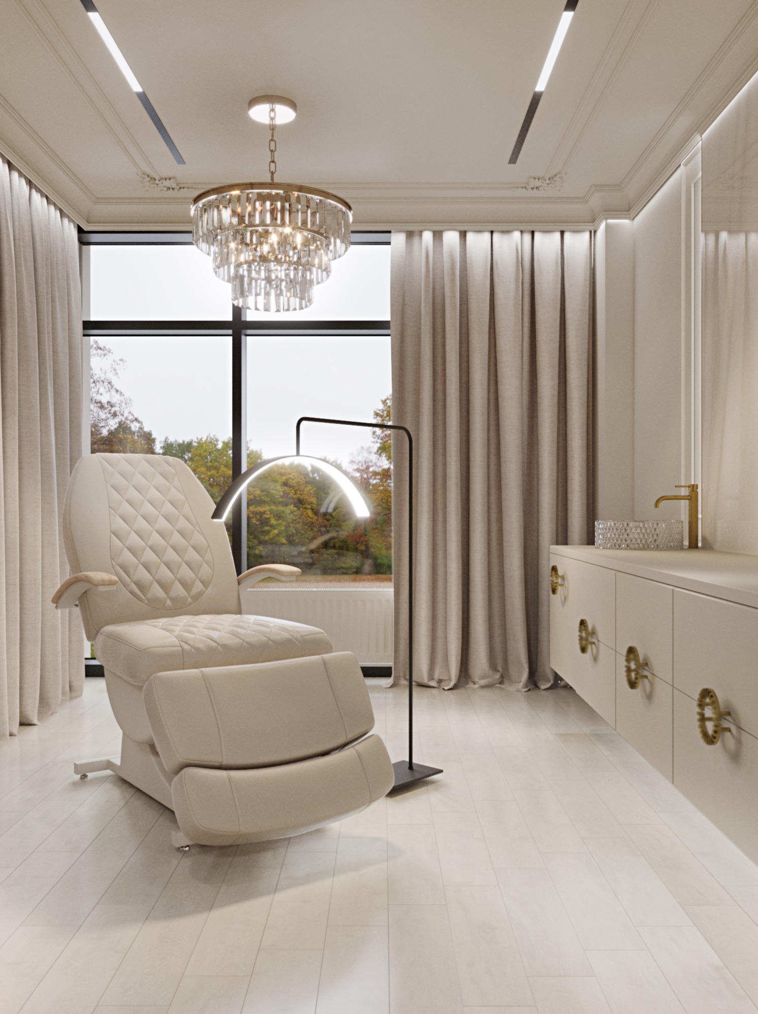 Jasne wnętrze z fotelem kosmetycznym z regulowanym podnóżkiem, nowoczesną lampą łukową, kryształowym żyrandolem i szafką z dekoracyjnymi uchwytami na tle okna z widokiem na jesienne drzewa.