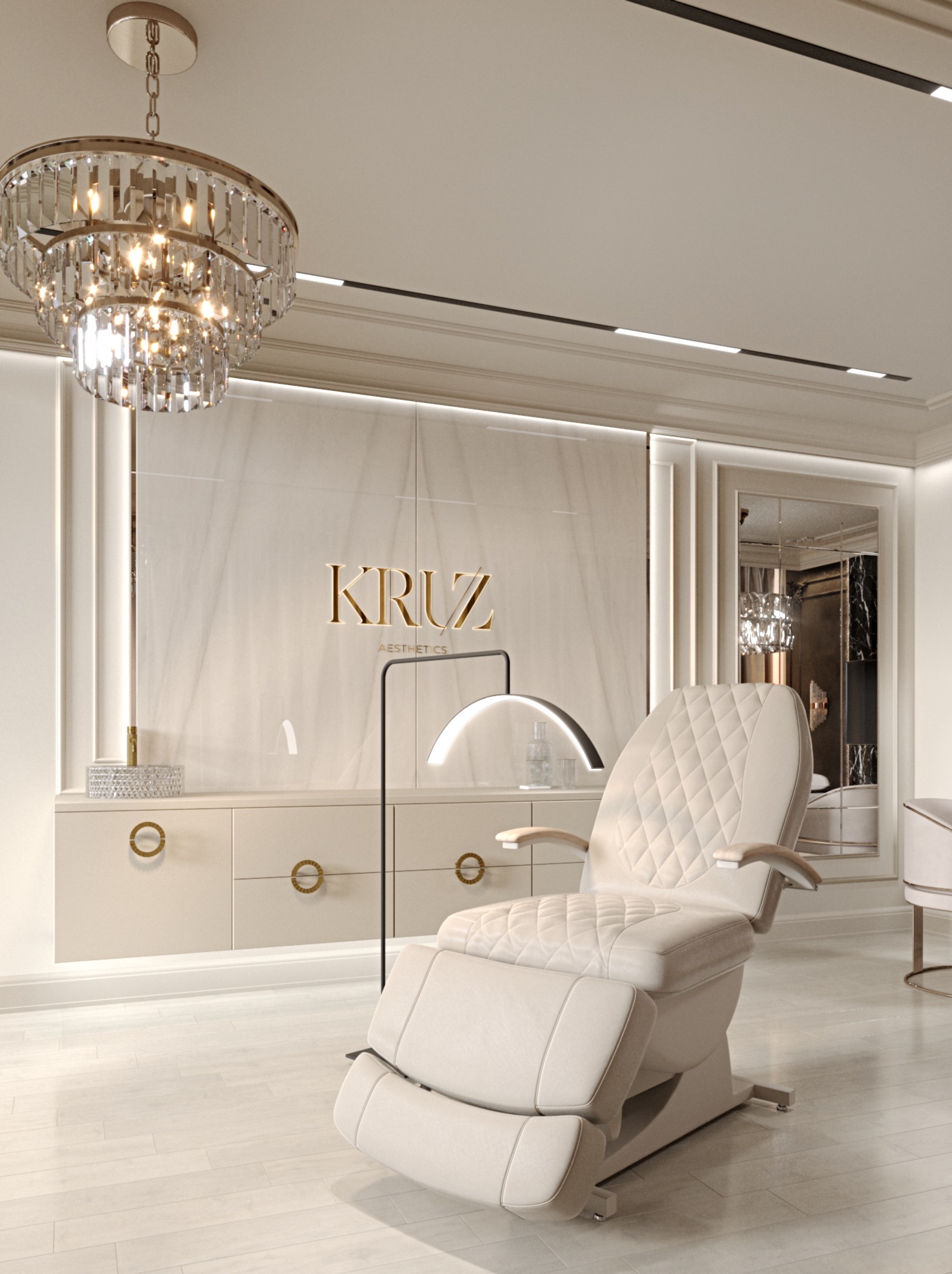 Elegancki gabinet kosmetyczny z beżowym fotelem zabiegowym obitym pikowaną skórą, podświetlonym łukową lampą, na tle zabudowy z marmurowym panelem i lustrem, oświetlony kryształowym żyrandolem.