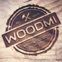 Wyżłobione logo firmy WOODMI na drewnianej desce, z datą EST. 2020 i imieniem projektanta Michał Pociecha, z motywem skrzyżowanego młotka i piły w okrągłej ramie.