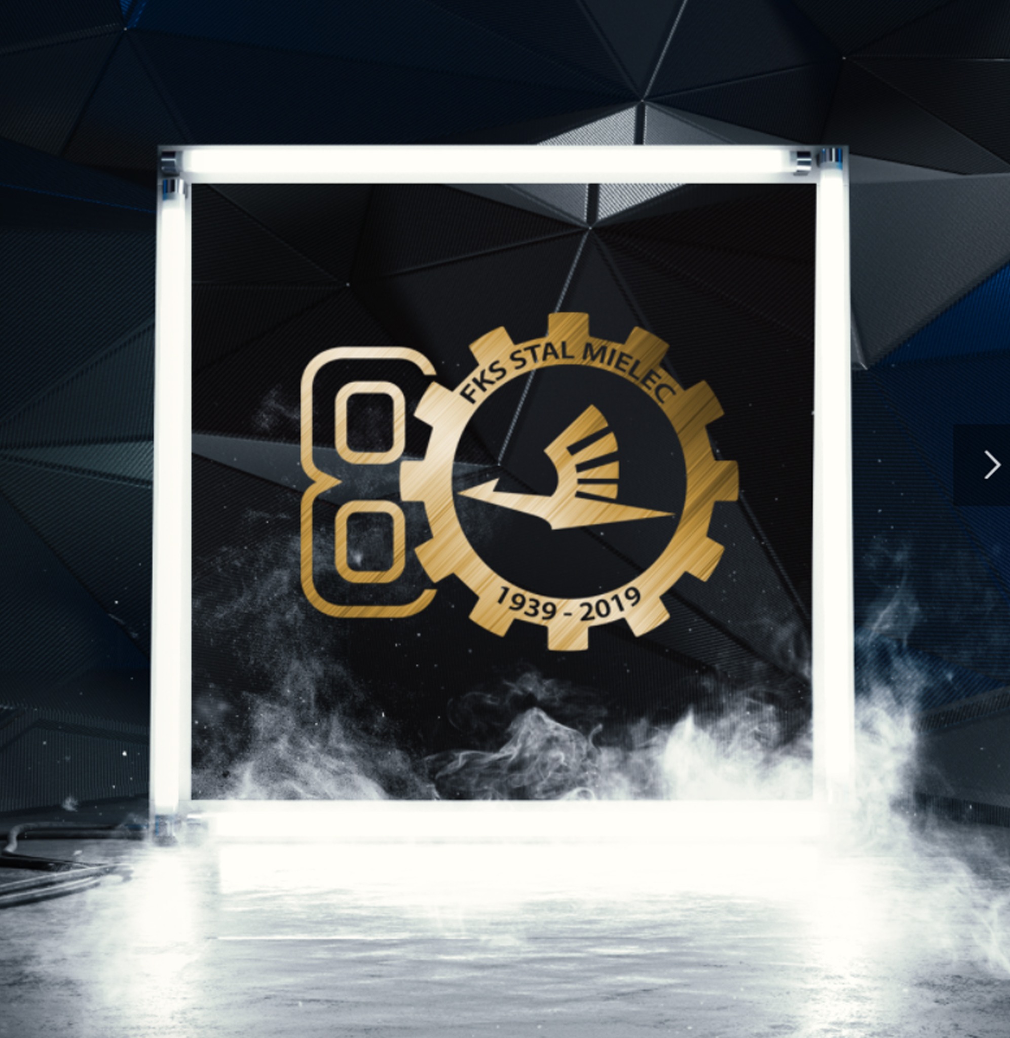 Złote logo FKS Stal Mielec na tle w kształcie koła zębatego, umieszczone w świecącej, białej ramie w futurystycznym otoczeniu z efektem dymu.