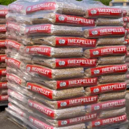 Stos worków z pelletem drzewnym marki Imexpellet, ułożonych na palecie i owiniętych folią, z widocznym oznaczeniem EN A1 plus.