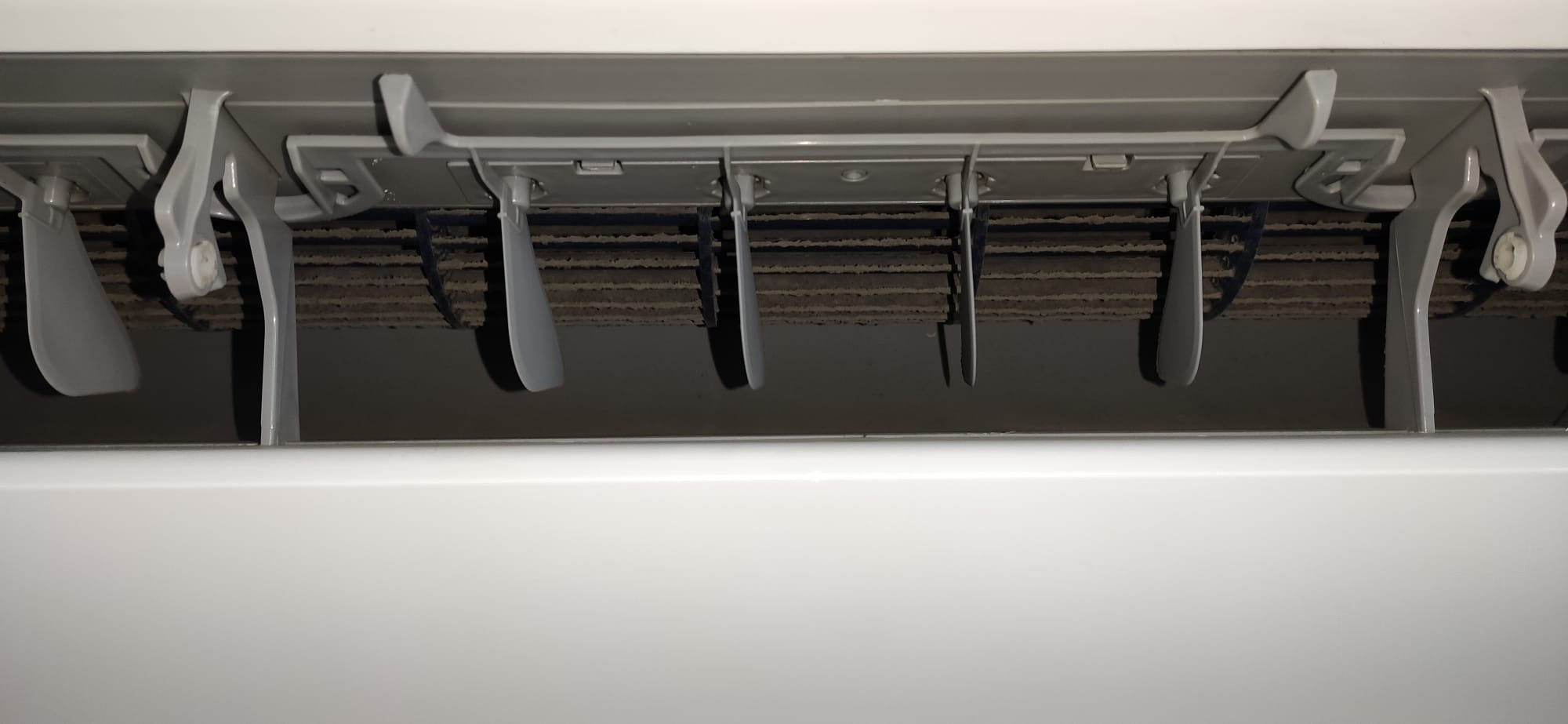 Zanieczyszczone filtry powietrza klimatyzatora, widoczne lamele kierujące powietrze.