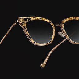 Studio Migafka - Eleganckie okulary przeciwsłoneczne z gradientowymi szkłami i złotymi zdobieniami na oprawkach, unoszące się na czarnym tle.