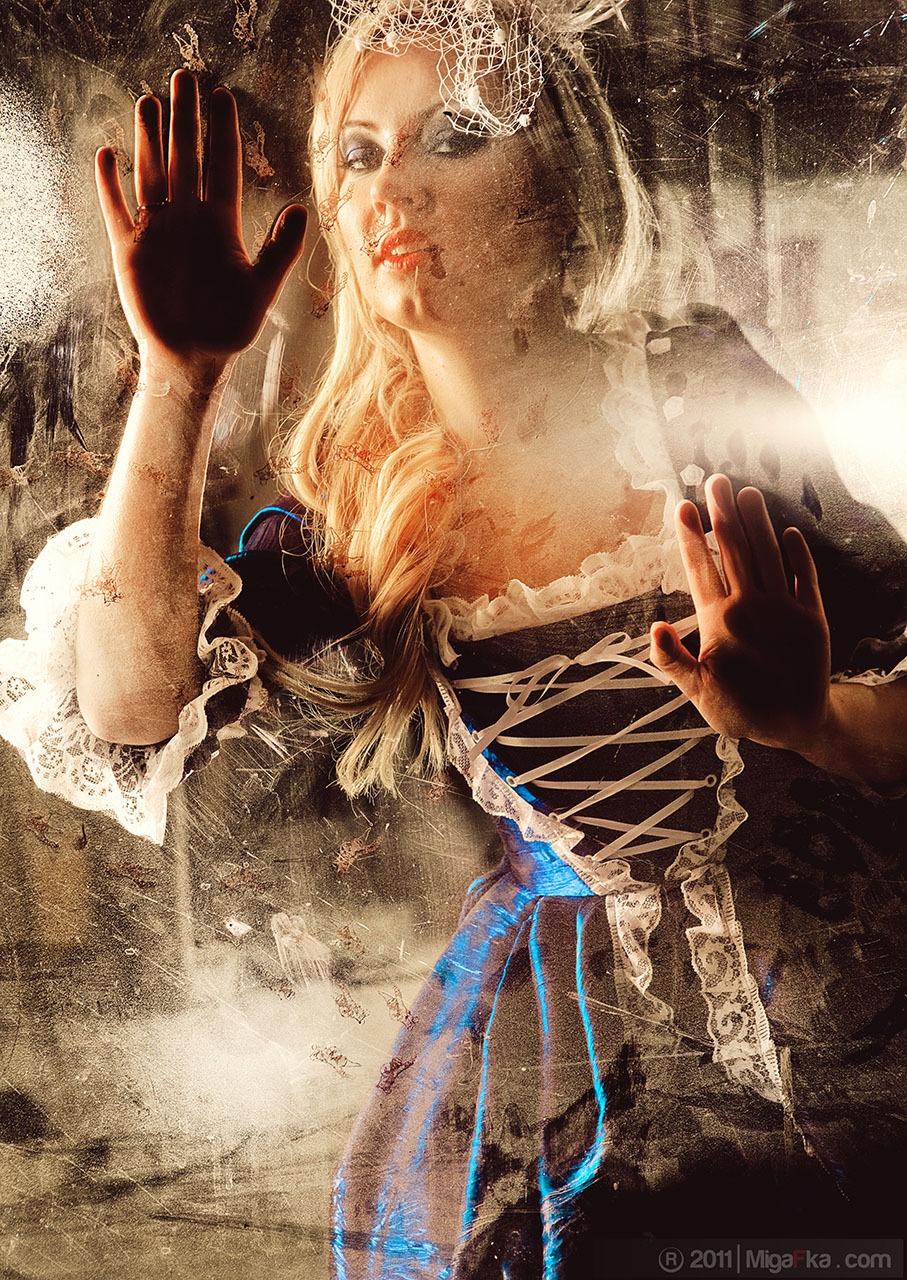 Blond kobieta w stylizowanej sukni z koronką i woalką dotyka brudnej szyby, patrząc w obiektyw, z efektem ziarnistości i vintage.