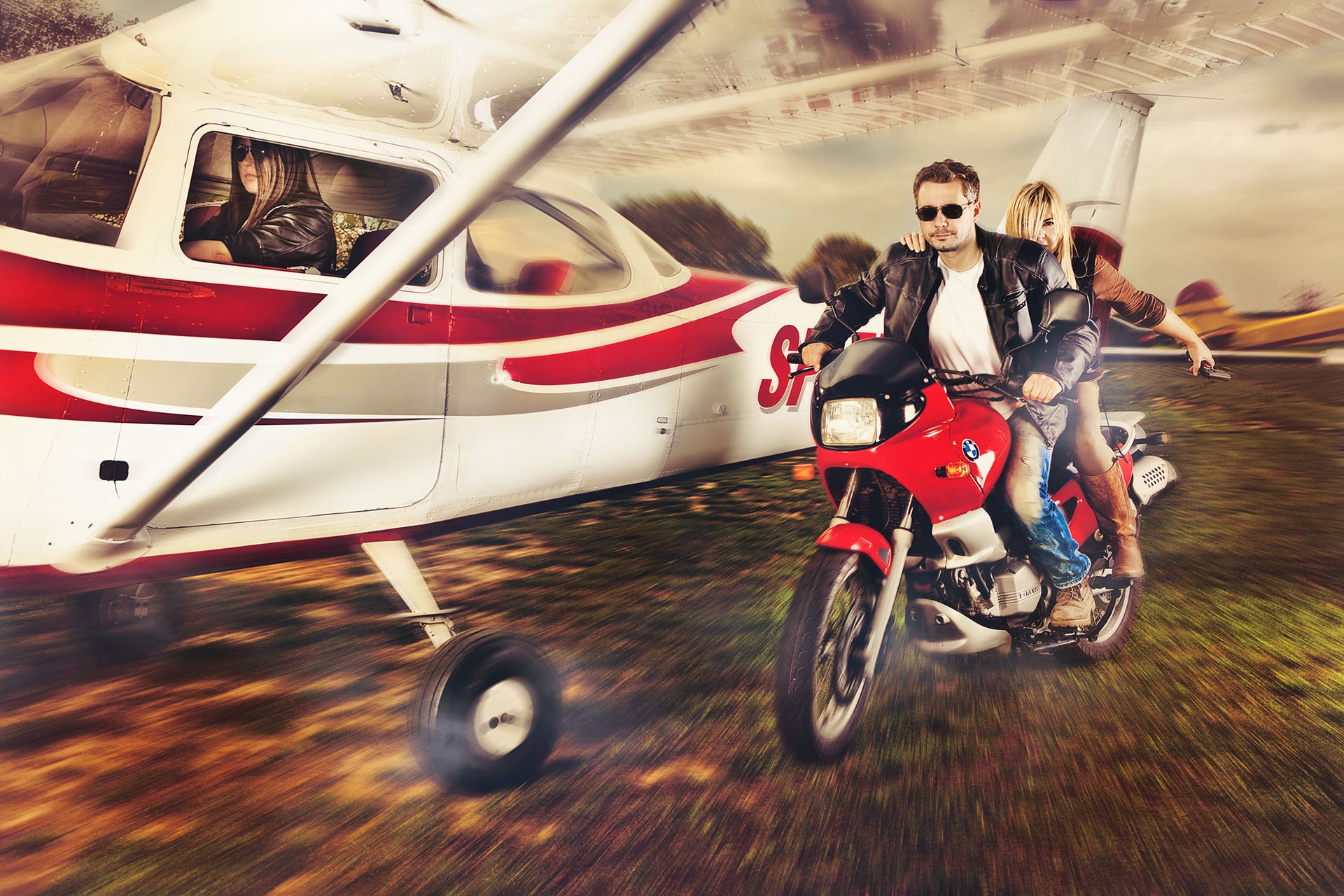 Dynamiczne ujęcie: para na czerwonym motocyklu, kobieta z pistoletem, na tle samolotu z kobietą w kabinie, efekt rozmycia ruchu.