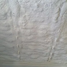 Ocieplenie poddasza pianką PUR w Kraśniczynie. Widoczne równomierne pokrycie izolacją, z detalami struktury pianki i elementami konstrukcyjnymi.