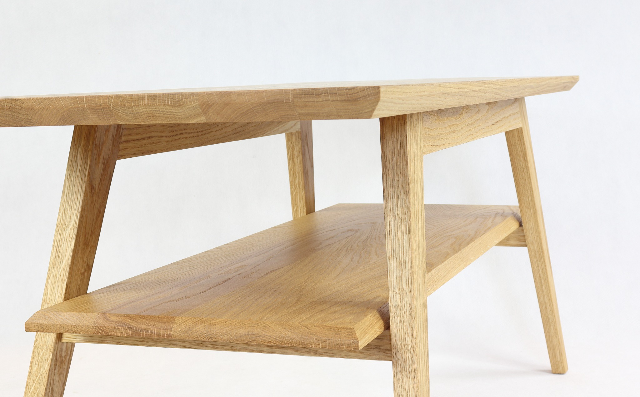 Drewniany stolik kawowy z półką, wykonany z jasnego drewna dębowego, prezentowany na białym tle w Olsztynie. Widoczne delikatne usłojenie drewna i minimalistyczny design.