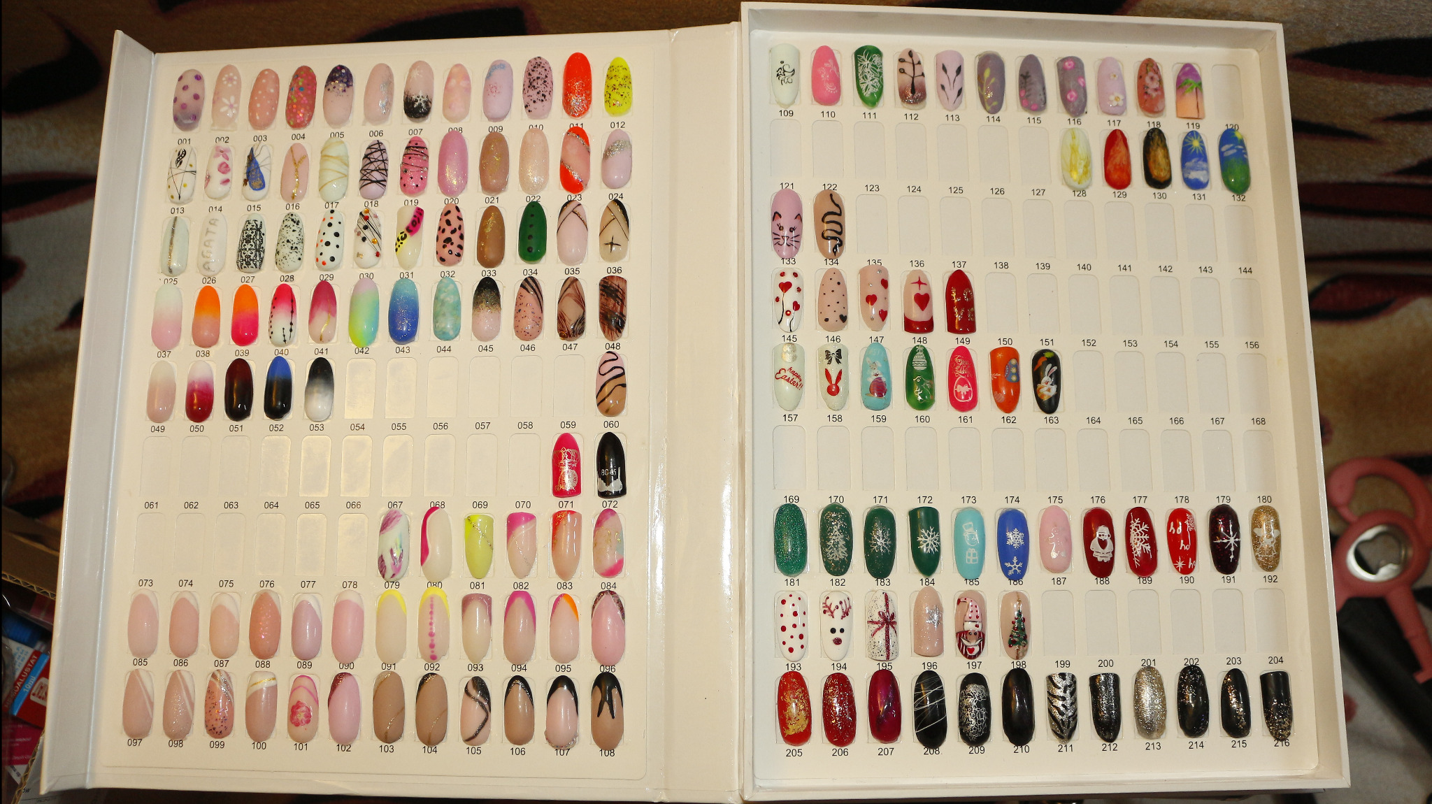 Prezentacja wzorów zdobień paznokci w palecie z numerami, obejmująca różnorodne style, kolory i motywy, od minimalistycznych po świąteczne i abstrakcyjne.