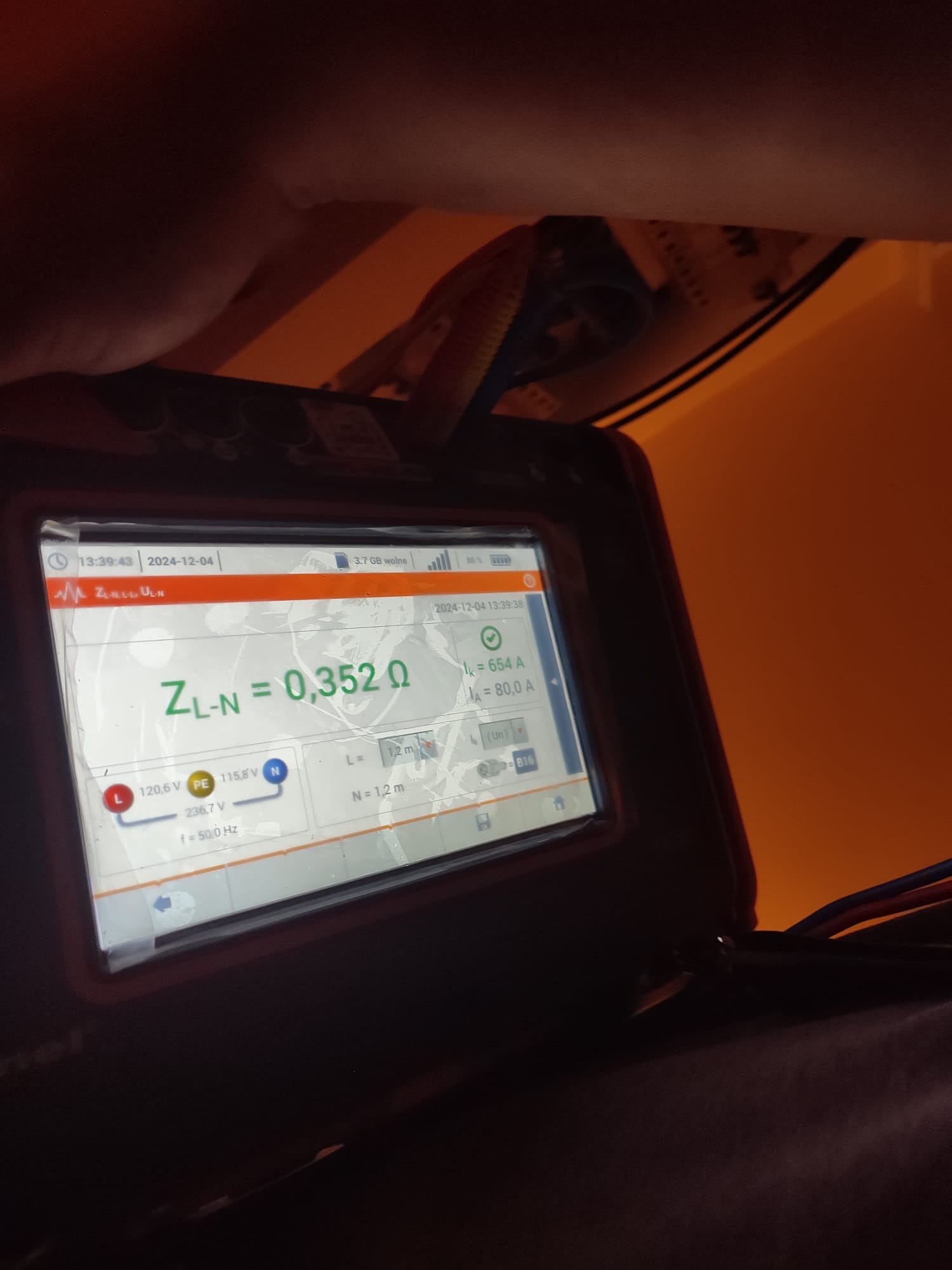 Miernik elektryczny wyświetlający wynik pomiaru impedancji pętli zwarcia ZL-N wynoszący 0,352 Ω, napięcia L-N 236.7V, L-PE 120.6V, N-PE 115.8V, prąd zwarciowy Ik=654A, prąd zabezpieczenia Ia=80A...