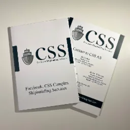 Dwa foldery reklamowe norweskiej firmy CSS Complex Shipbuilding Services z logo firmy i danymi kontaktowymi, leżące na białym tle.