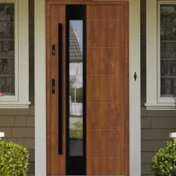 Nowoczesne drzwi zewnętrzne z drewna w odcieniach brązu z pionowym przeszkleniem i długim, czarnym uchwytem, zamontowane w domu z szarą elewacją i białymi ramami okiennymi.