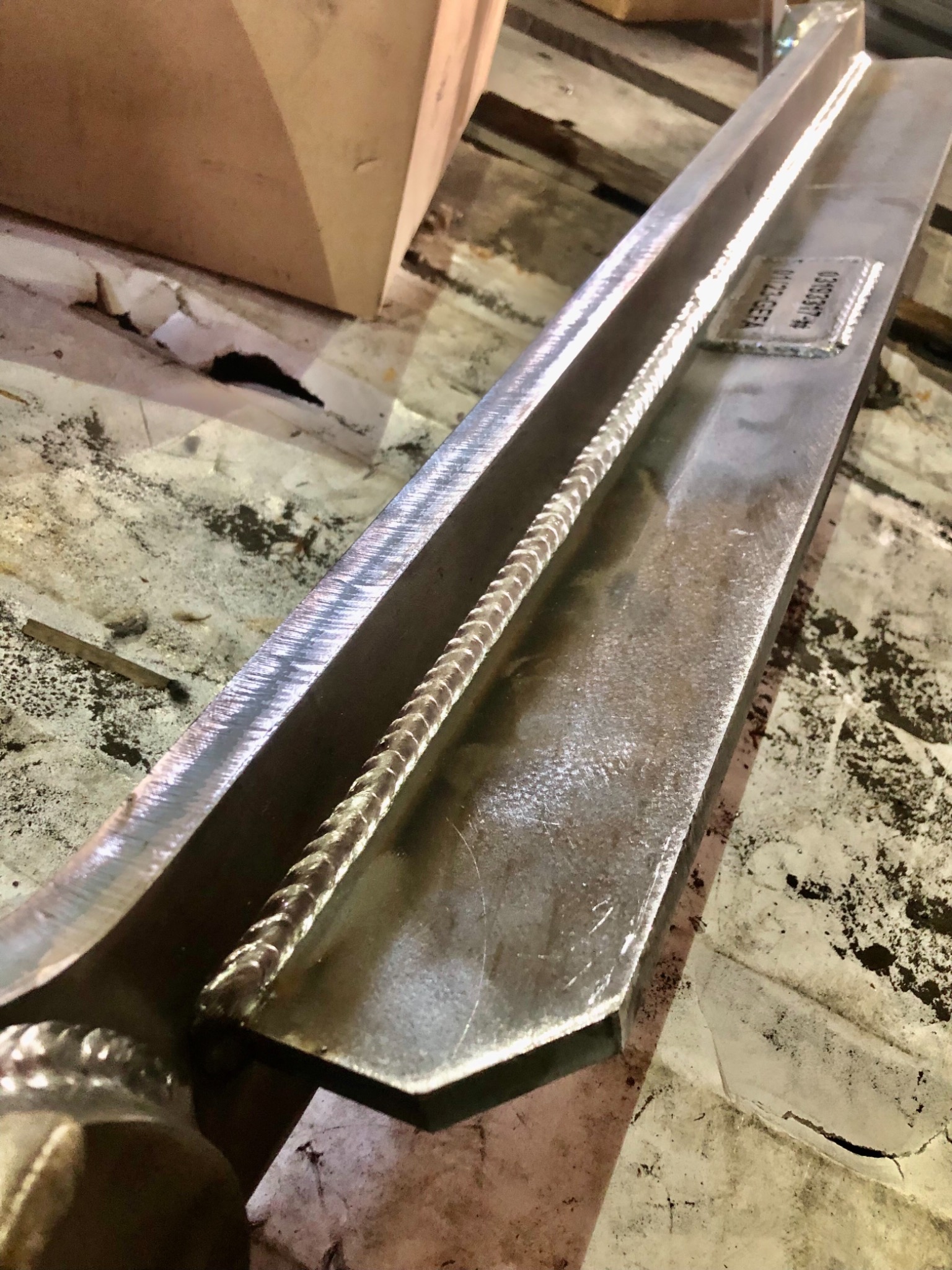 Metalowa belka z precyzyjnym spawem w Zielonej Górze, widoczna tabliczka z numerem seryjnym.