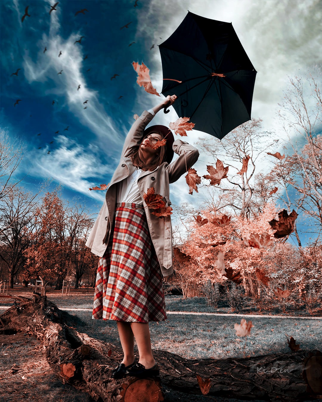 Kobieta w jesiennej scenerii, trzymająca parasol, otoczona spadającymi liśćmi, stojąca na pniu drzewa w parku, z ptakami na błękitnym niebie.