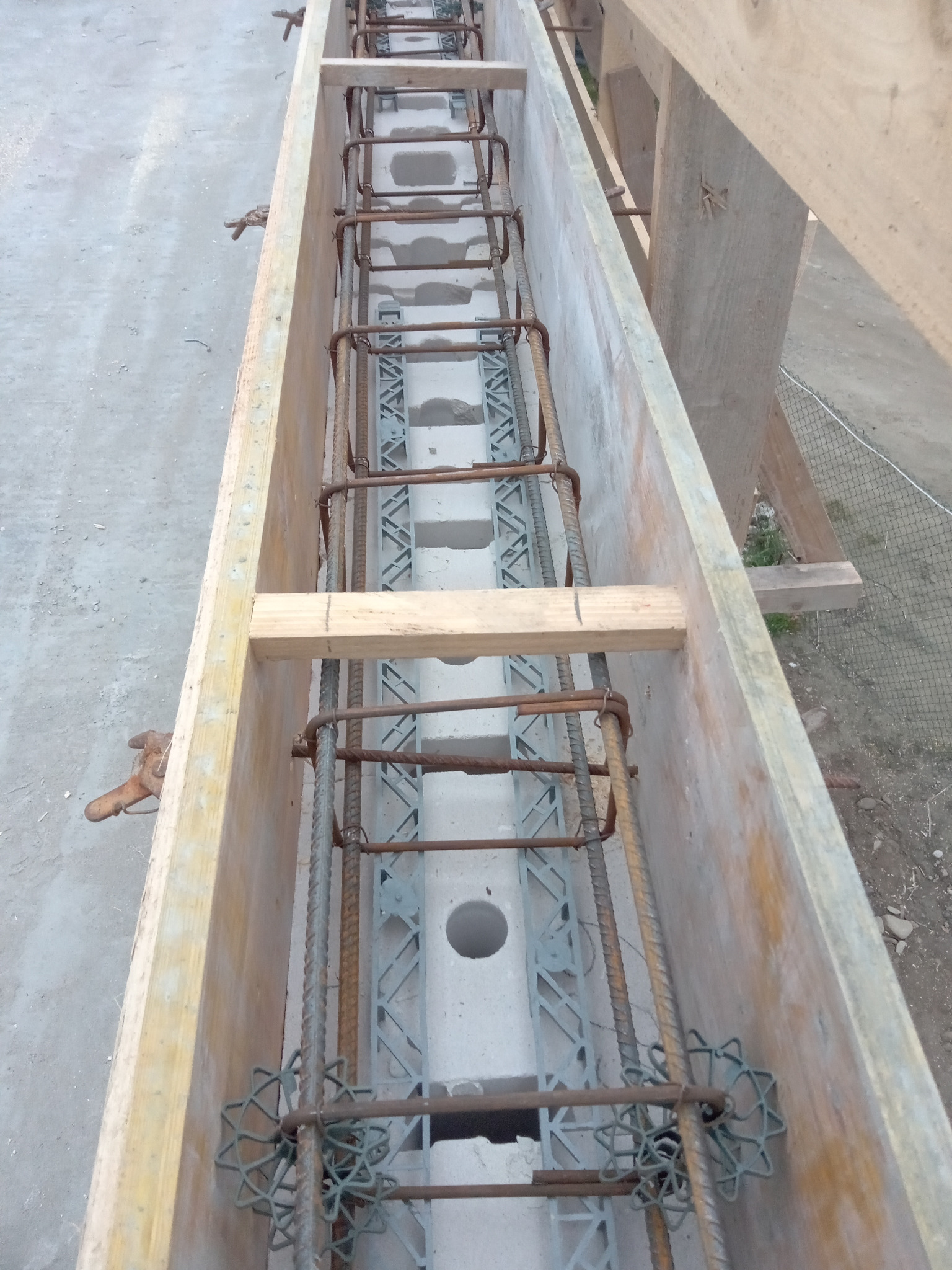 Szczegółowe ujęcie szalunku zbrojeniowego z widocznymi bloczkami betonowymi i elementami dystansowymi, przygotowany do zalania betonem.