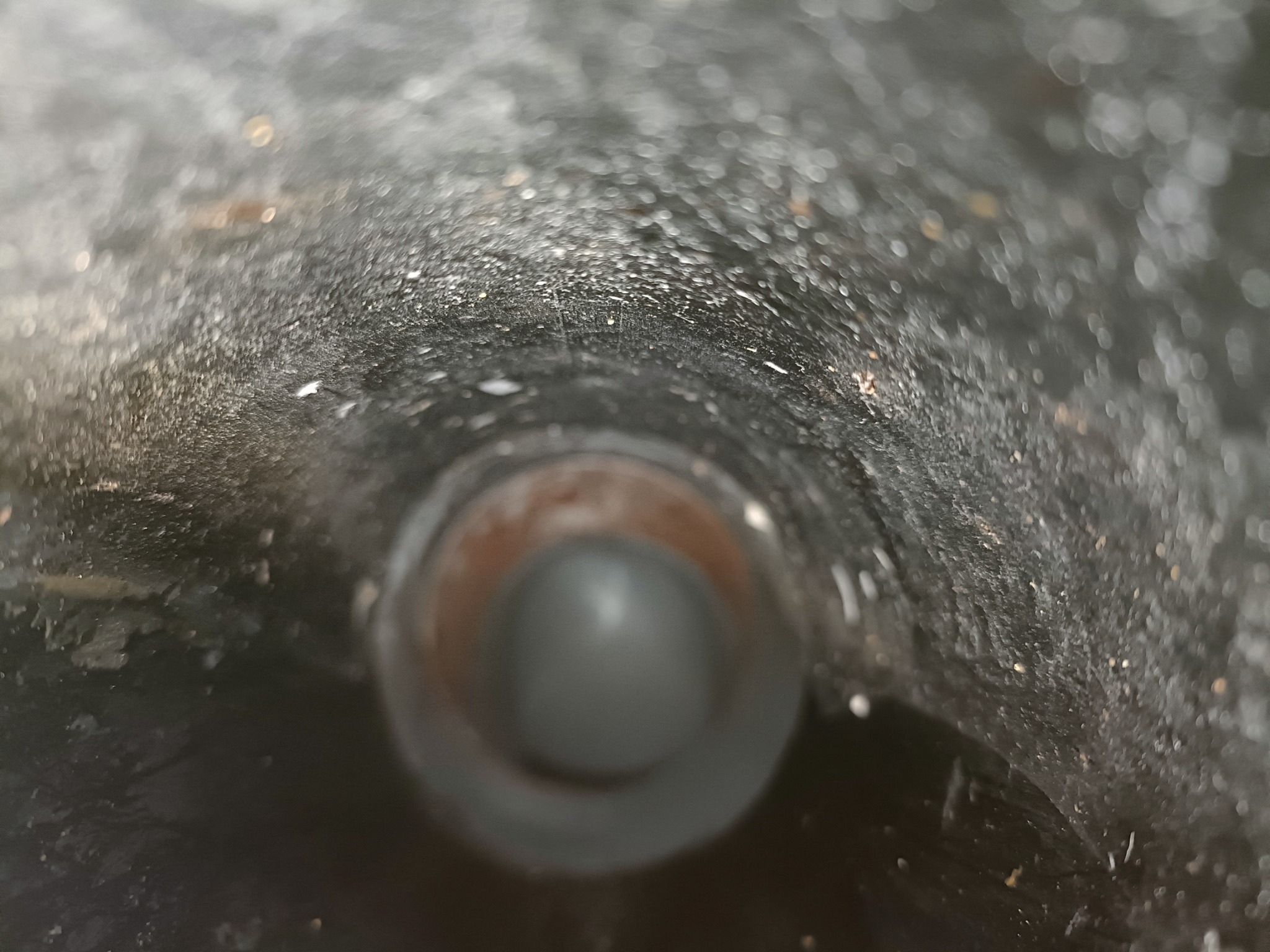 Wnętrze brudnej, ciemnej rury kanalizacyjnej widziane z bliska, z widocznym osadem i niewielkim odpływem.