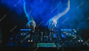DJ miksujący muzykę na profesjonalnym kontrolerze DJ-skim, oświetlonym niebieskim światłem i otoczonym dymem scenicznym.