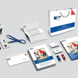 Komplet materiałów identyfikacji wizualnej Forum Młodych Przedsiębiorców: papier firmowy, wizytówki, torba reklamowa, identyfikator, pieczątka, pendrive i broszura informacyjna na szarym tle.