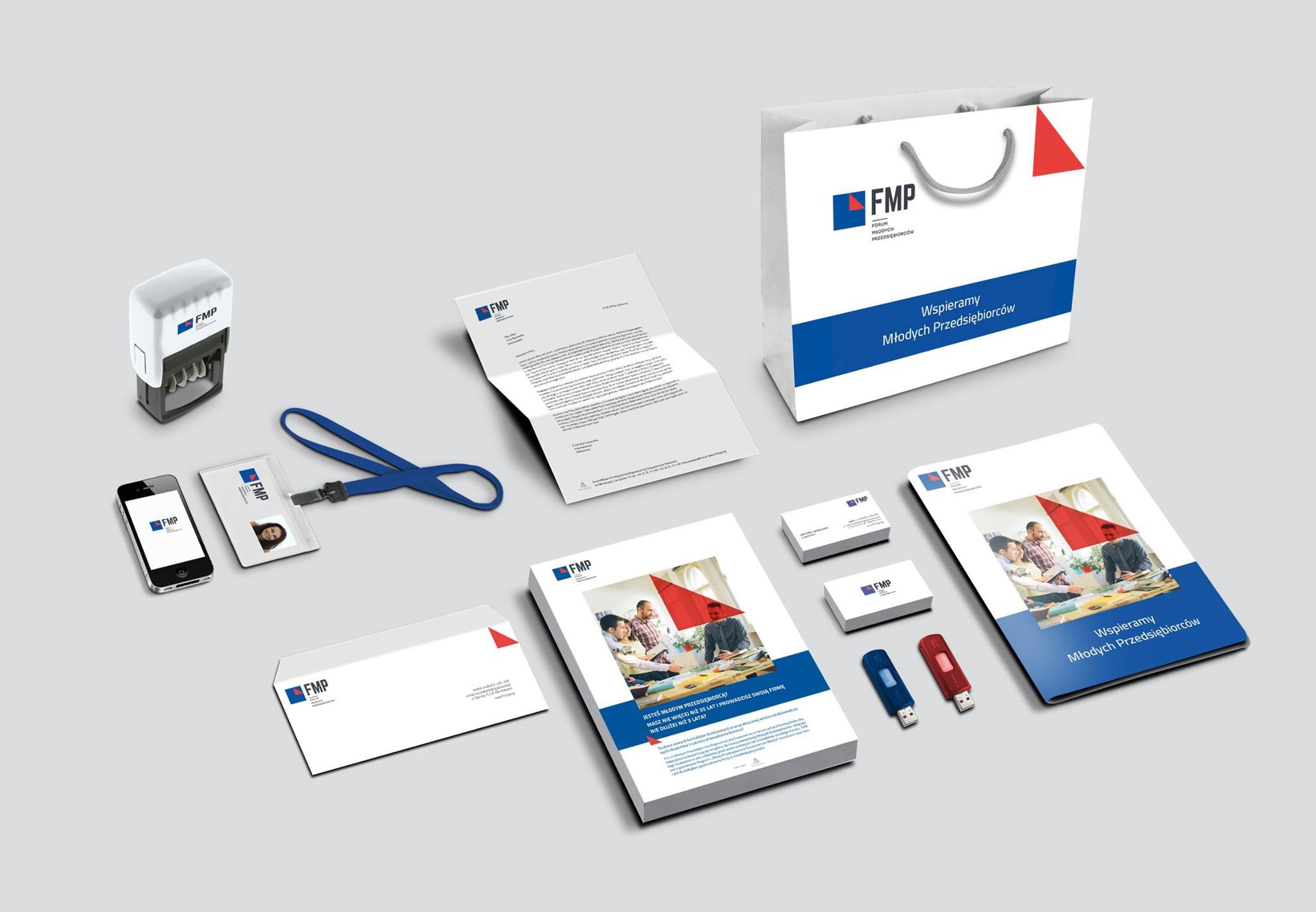 Komplet materiałów identyfikacji wizualnej Forum Młodych Przedsiębiorców: papier firmowy, wizytówki, torba reklamowa, identyfikator, pieczątka, pendrive i broszura informacyjna na szarym tle.