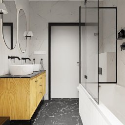 STYLOVE WNĘTRZA - Nowoczesna łazienka z dwoma umywalkami na drewnianej szafce, czarną armaturą, kabiną prysznicową i marmurowymi płytkami na ścianach, uzupełniona zieloną rośliną w doniczce.