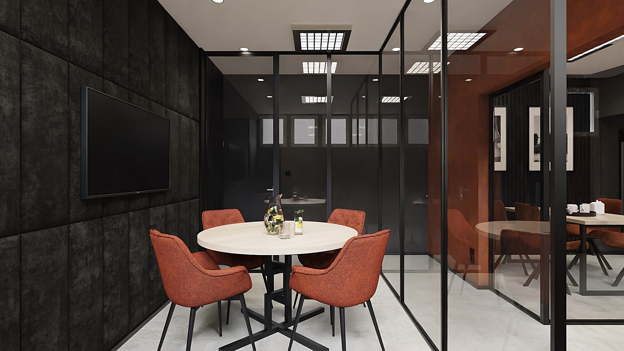 Nowoczesna sala konferencyjna z przeszklonymi ścianami, okrągłym stołem z czterema krzesłami w kolorze terakoty, czarną ścianą z telewizorem i widokiem na drugą salę konferencyjną.