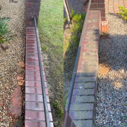 Jaksiepatrzy24 - Dwa fragmenty murków z czerwonej cegły oddzielające trawnik i kamienny ogródek, widoczne ślady mycia pod ciśnieniem, po lewej świeżo umyty, po prawej jeszcze zabrudzony mchem i porostami.