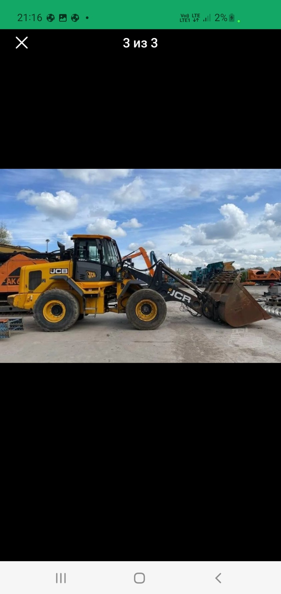 Żółto-czarna ładowarka teleskopowa JCB na placu budowy z innymi maszynami w tle, widok z boku, pochmurne niebo.