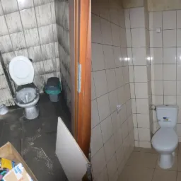 Porównanie łazienki przed i po: po lewej toaleta z widocznymi śladami zalania i pleśni na ścianach i podłodze, po prawej czysta, odnowiona toaleta z jasnymi płytkami.