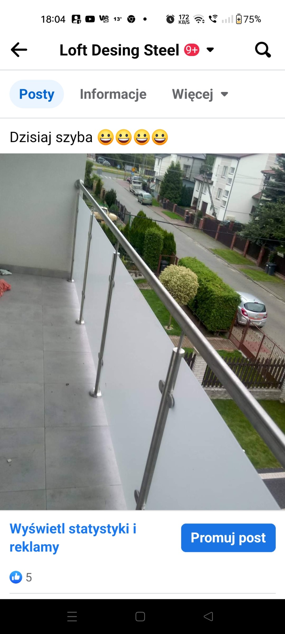 Nowoczesna balustrada balkonowa ze szkła i stali nierdzewnej, widok z góry na ulicę z domami i zielenią.