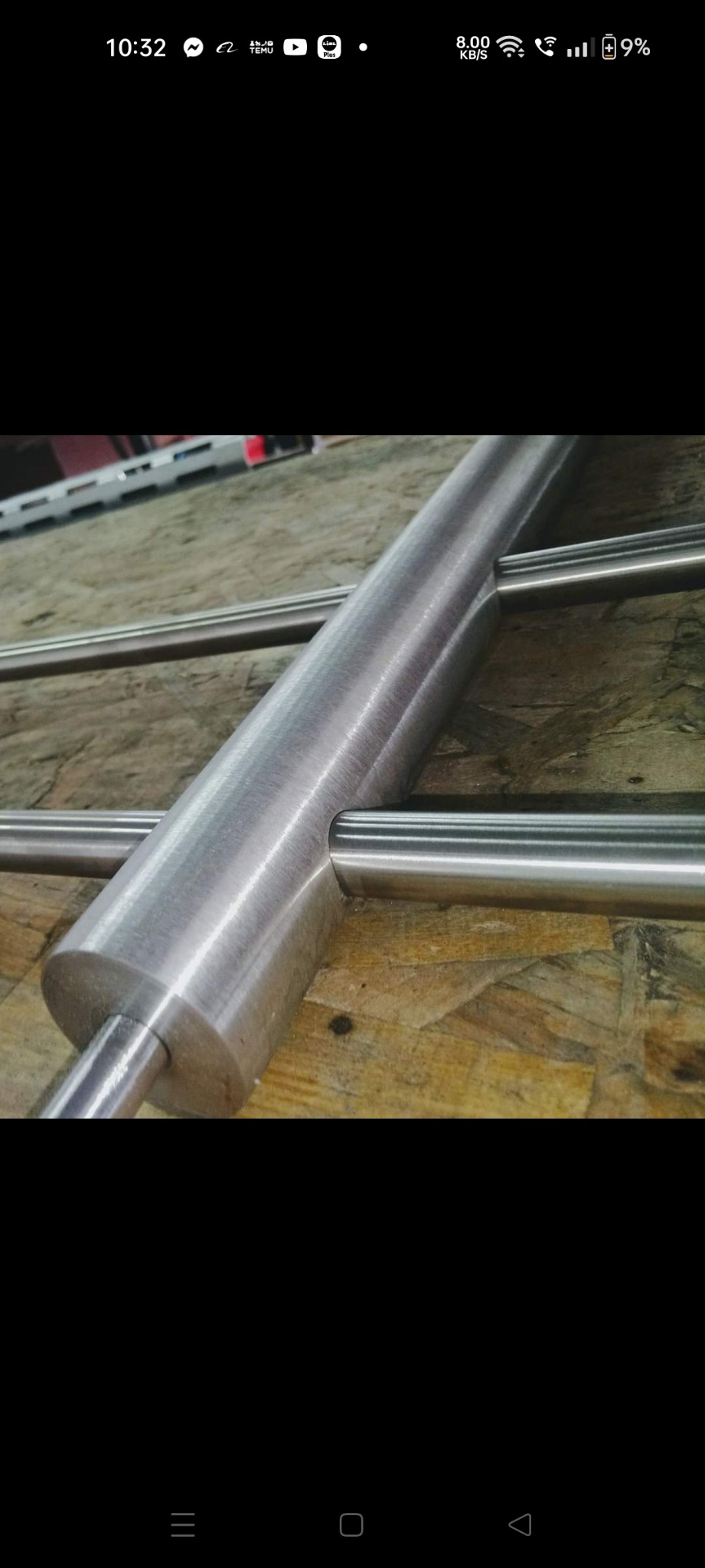 Szczegółowe ujęcie spawu łączącego rury ze stali nierdzewnej, ukazujące precyzję wykonania i gładkie wykończenie na tle płyty OSB.