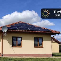 Panele - Dom jednorodzinny z panelami słonecznymi na dachu z czerwonej dachówki, antena satelitarna i logo firmy Tuchola 3,52 kWp w prawym górnym rogu.