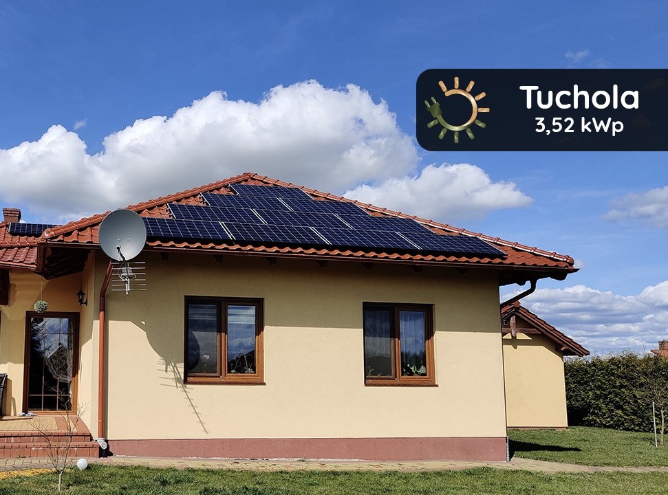 Dom jednorodzinny z panelami słonecznymi na dachu z czerwonej dachówki, antena satelitarna i logo firmy Tuchola 3,52 kWp w prawym górnym rogu.