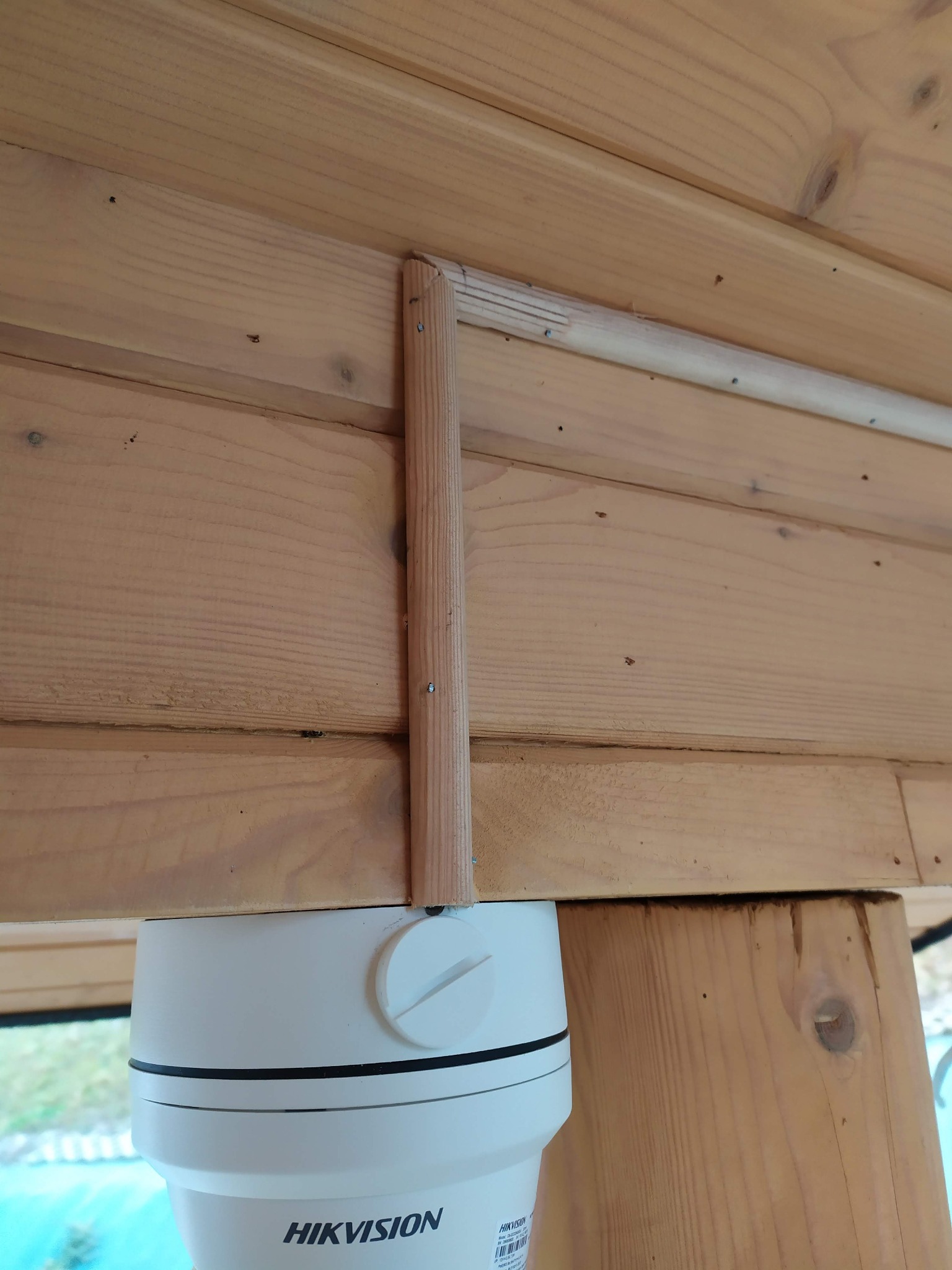 Kamera Hikvision zamontowana na drewnianej konstrukcji, zabezpieczona listwami wykończeniowymi.