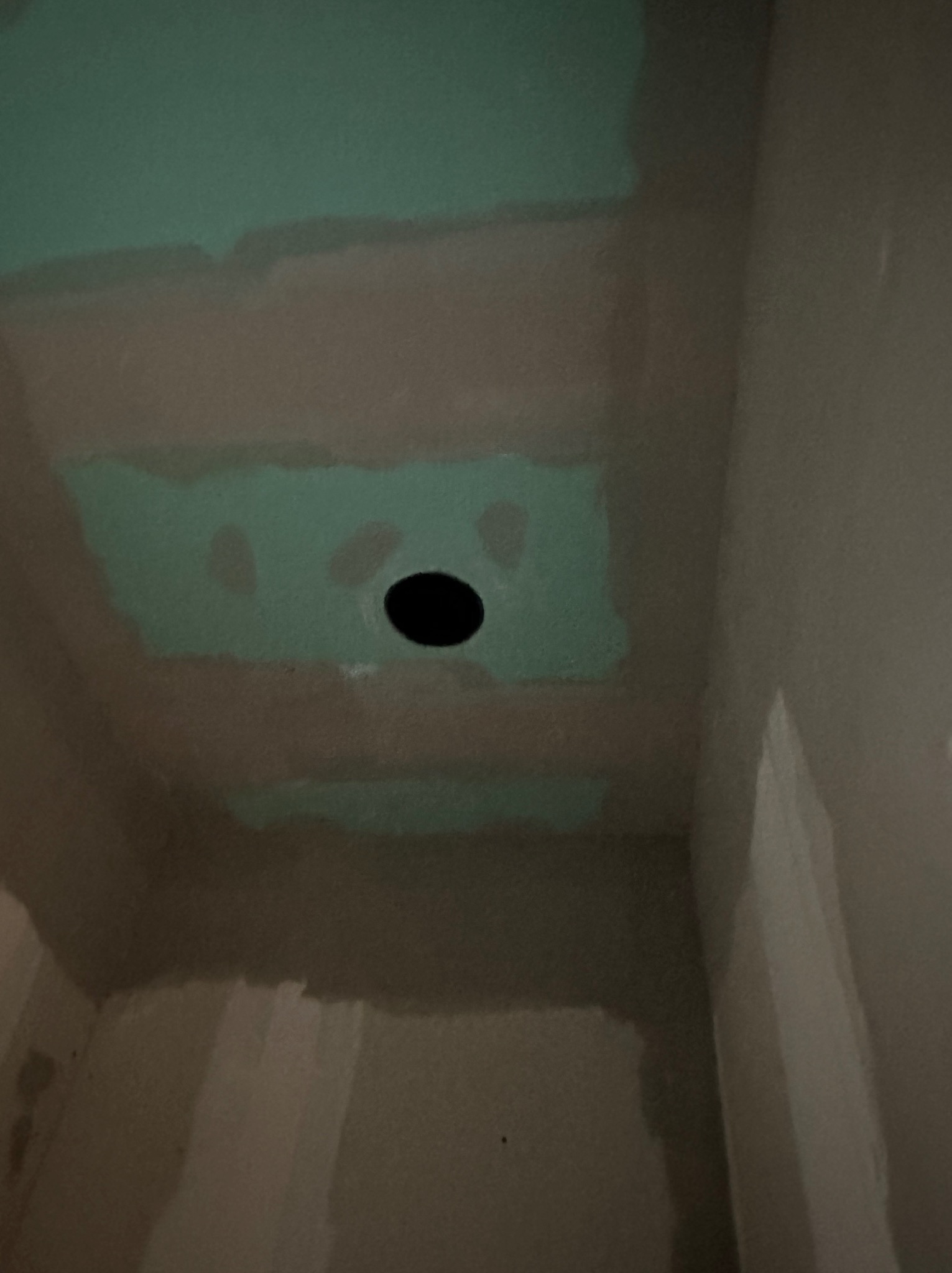 Surowy sufit i ściany w trakcie prac wykończeniowych, widoczne łączenia płyt gipsowo-kartonowych, otwór na oświetlenie i ślady po szpachlowaniu.