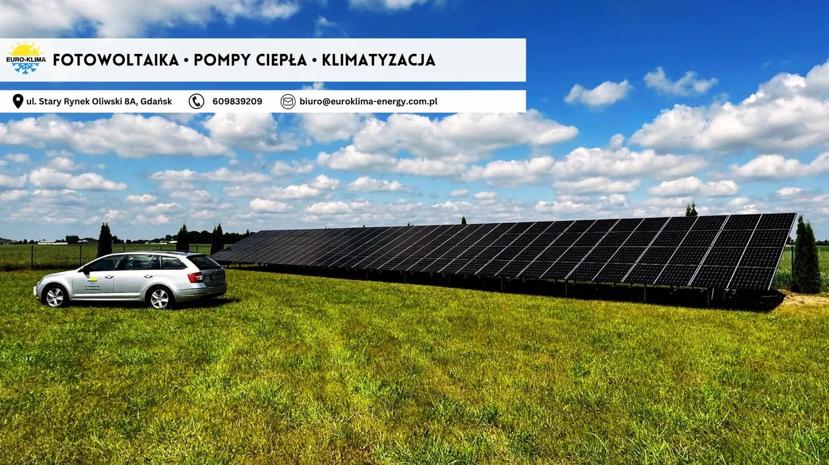 Instalacja fotowoltaiczna na zielonym terenie z zaparkowanym samochodem osobowym firmy Euro-Klima w Gdańsku, na tle błękitnego nieba z chmurami.