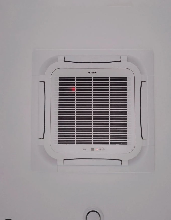 Kasetonowa jednostka klimatyzacji Gree zamontowana w suficie w Ostrowie Wielkopolskim, widoczna czerwona dioda sygnalizacyjna.