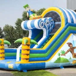 Nadmorski dmuchany zamek ze zjeżdżalnią w kształcie fali, udekorowany palmami i postacią surfera