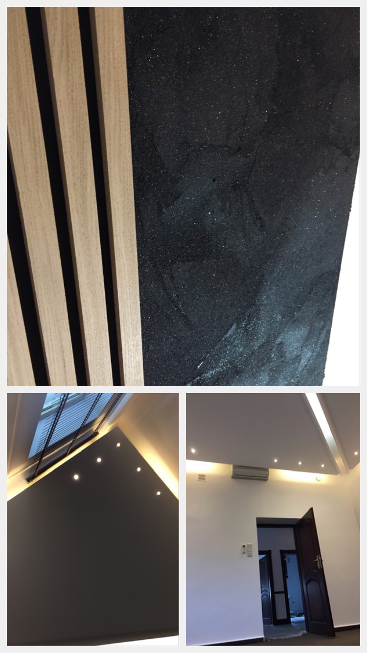 Panel ścienny z drewnianych listew sąsiadujący z czarną, błyszczącą ścianą; widok na sufit z oświetleniem punktowym i klimatyzacją nad otwartymi drzwiami.