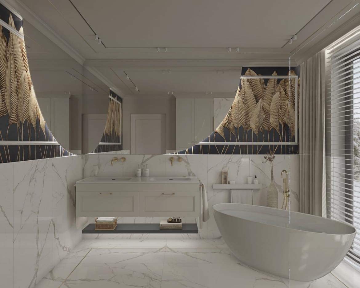 Elegancka łazienka z marmurowymi płytkami, wolnostojącą wanną i lustrem odbijającym dekoracyjną tapetę z motywem złotych liści.