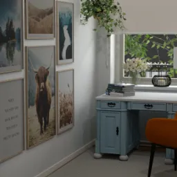 Niebieskie biurko z pomarańczowym krzesłem na tle ściany z wiszącymi obrazami krajobrazów i zwierząt, oraz okno z roślinami i lampką.