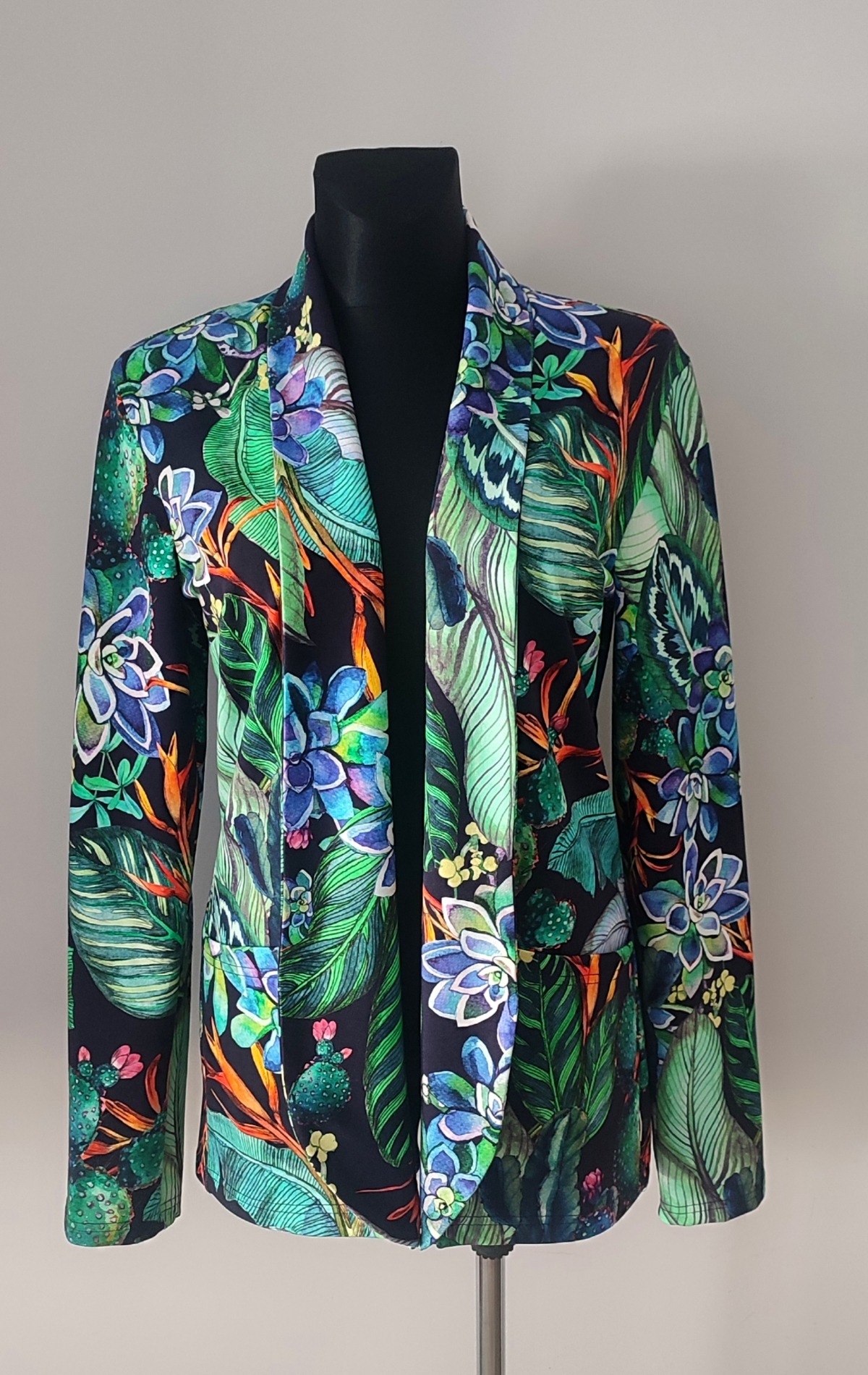 Żakiet damski z tropikalnym wzorem, prezentowany na czarnym manekinie.