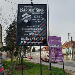 Greenwood Grzegorz Dziergas - Duży, czarny szyld reklamowy fryzjera męskiego Barber Shop Mirosław Golański z grafiką brzytwy i kapelusza, obok mniejszy, fioletowy szyld salonu fryzur Miratrend Mirosław Golański, oba szyldy...