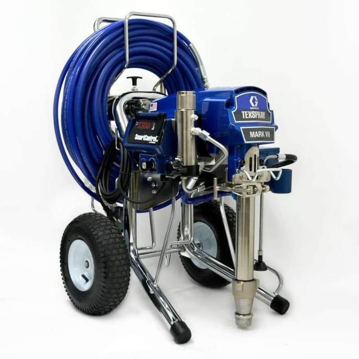 Profesjonalny agregat malarski Graco Texspray Mark VII na chromowanym wózku z nawiniętym niebieskim wężem, widoczne logo producenta.