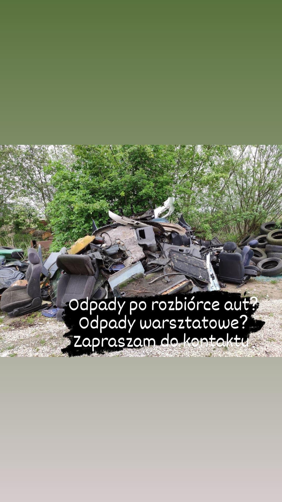 Stos odpadów po demontażu samochodów, w tym siedzenia, opony i elementy karoserii, składowane na zewnątrz na tle zieleni.