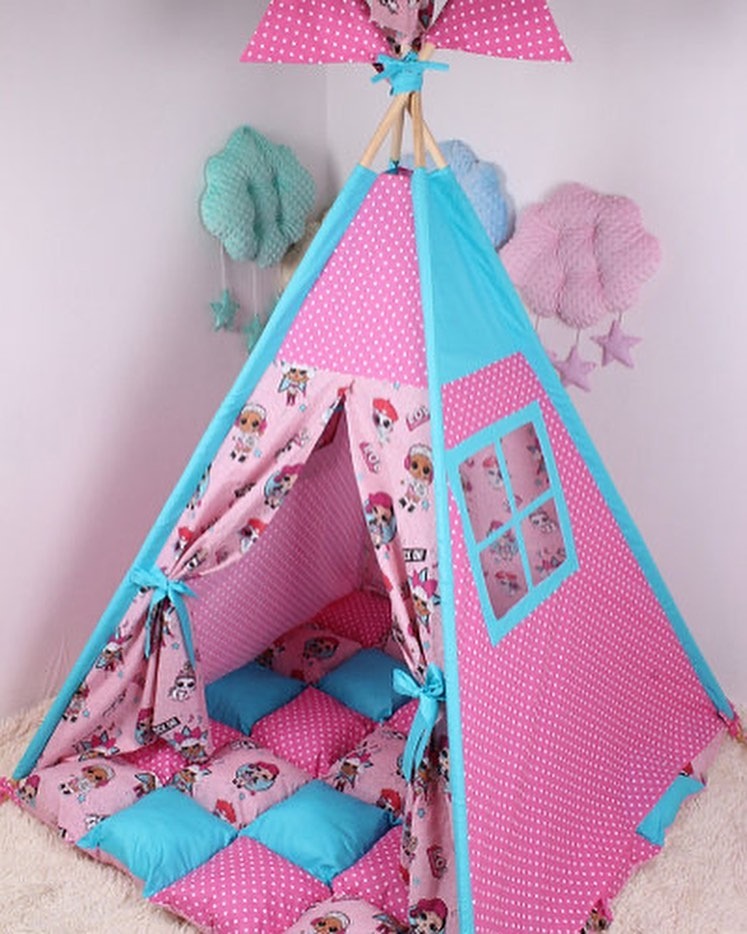 Różowo-turkusowy namiot tipi dla dzieci z okienkiem, poduszki wewnątrz, wiszące dekoracje w tle.