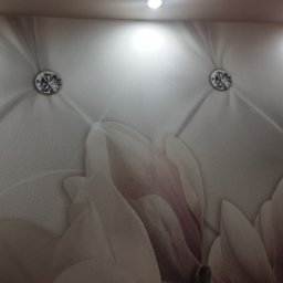 Firma Usługowa Złota Rączka Piotr Mikulewicz - Tapeta z motywem kwiatowym i pikowaniem, zdobiona kryształkami, oświetlona punktowo. Dekoracyjne wykończenie ściany w jasnych barwach.