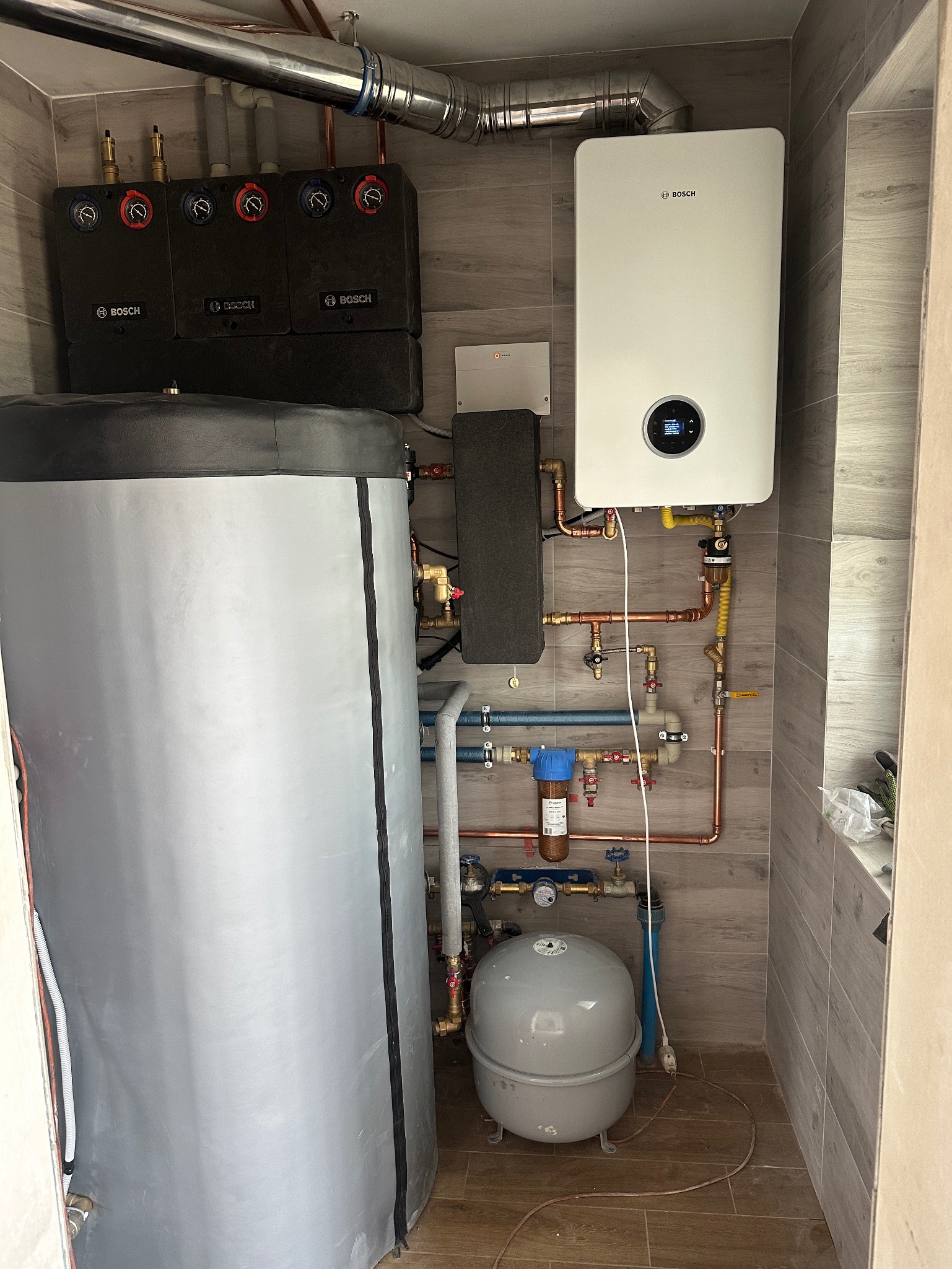 Hybrydowe rozwiązanie z zastosowaniem kotła gazowego i kominka z płaszczem wodnym.