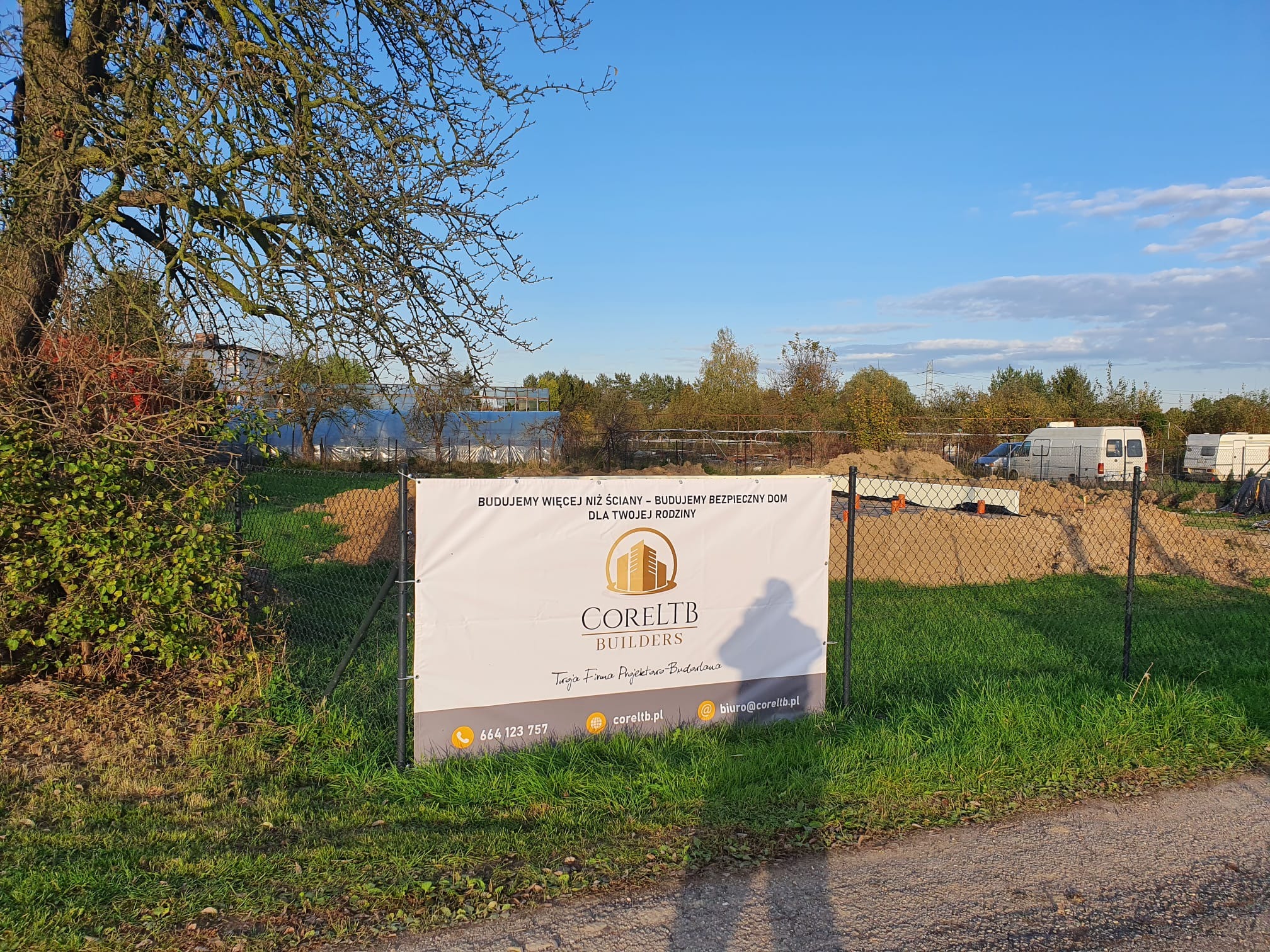 Baner reklamowy firmy budowlanej Coreltb Builders na tle placu budowy z widocznymi fundamentami i ogrodzeniem z siatki.